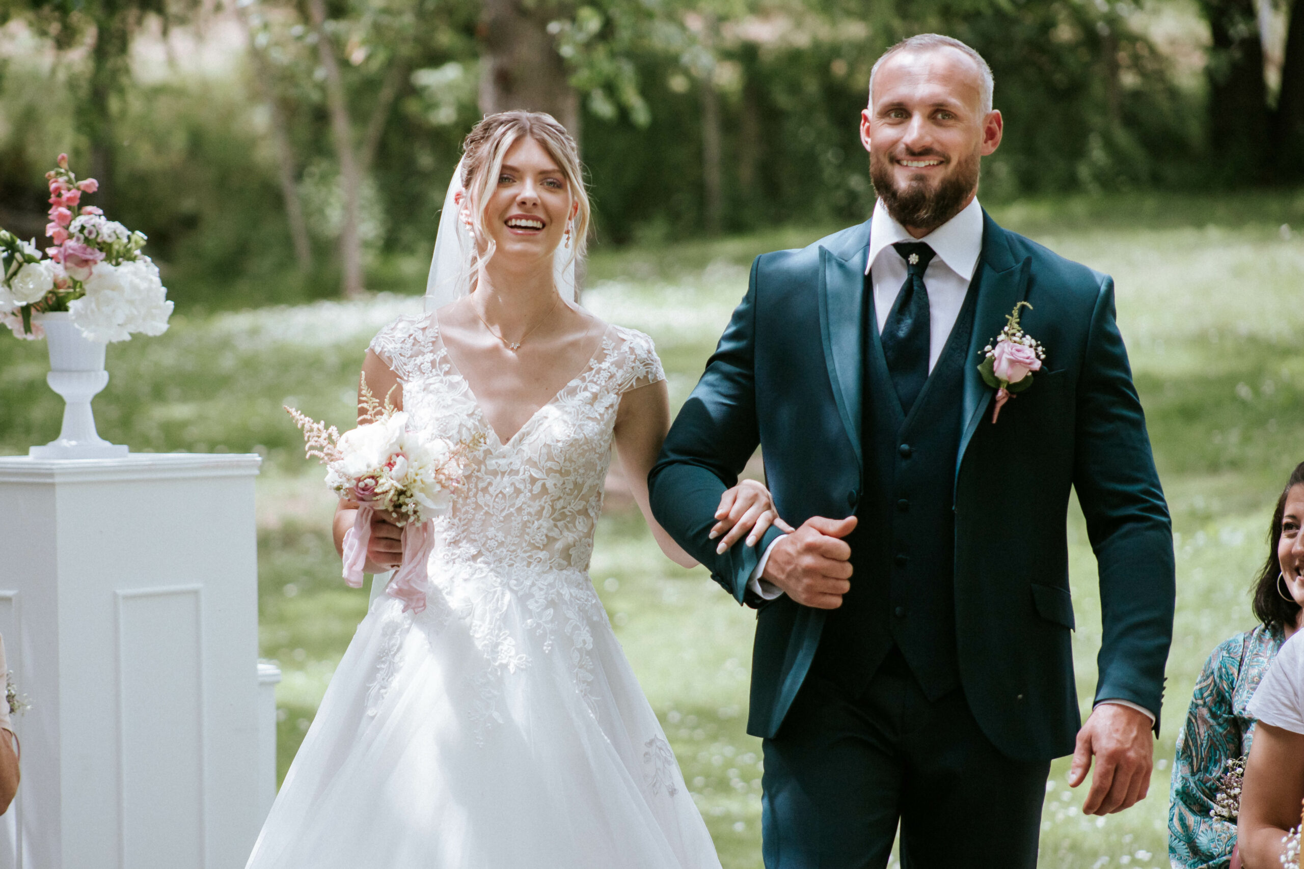 Photos de mariage- le couple qui arrive dans l'allée de la cérémonie laïque dans le jardin du Domaine d'En Naudet.