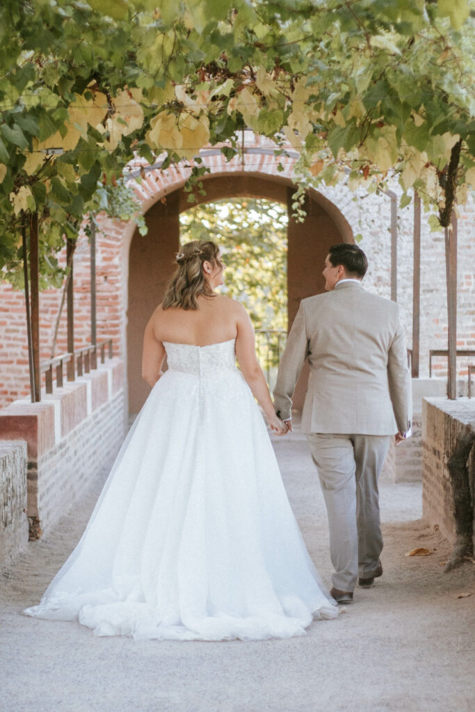 mariées qui marchent dans le parc Du palais de la BErbie, main dans la main, suivies par leur photographe de mariage