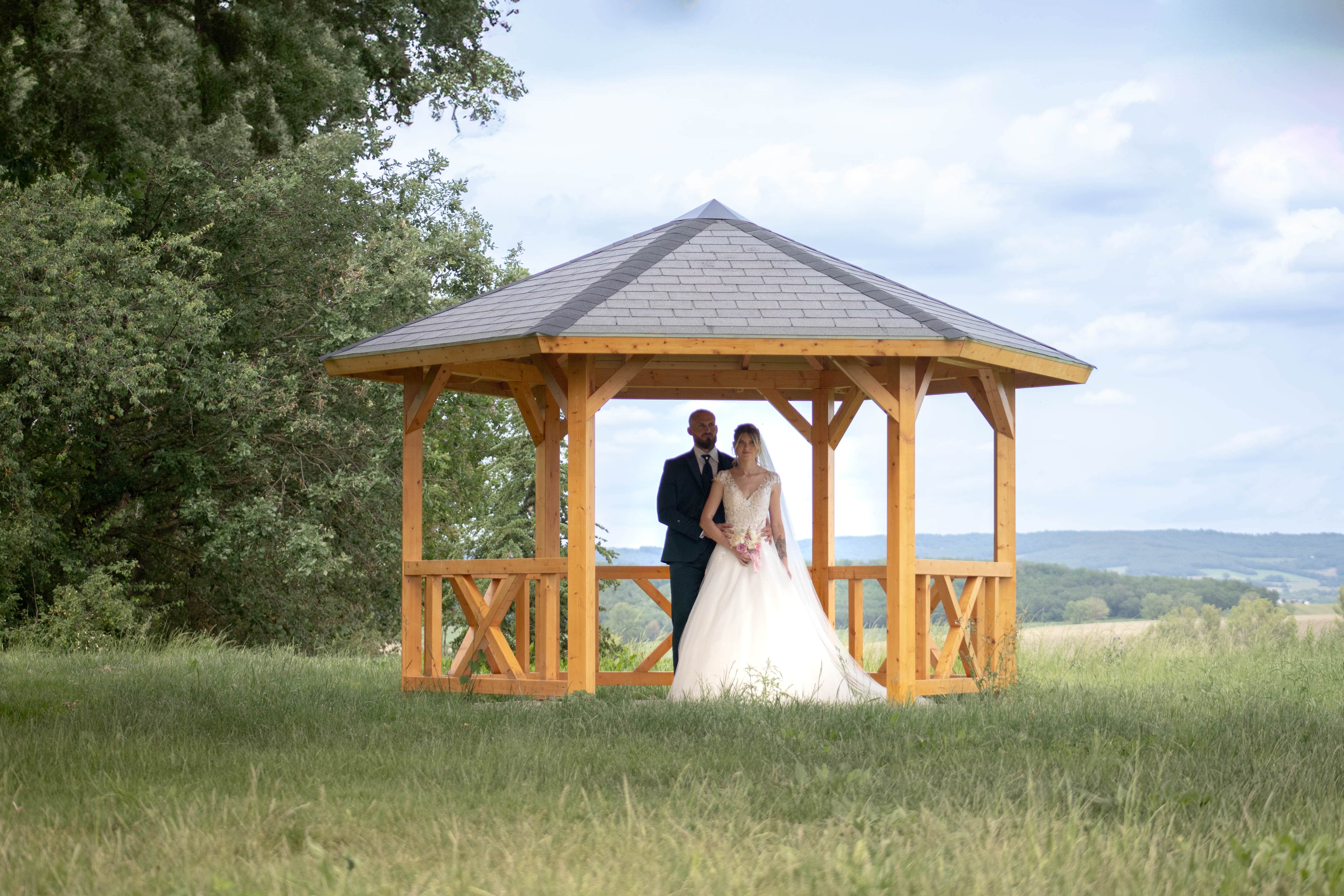 MAriées sous le porche, dans le grand jardin du domaine d'en naudet, dans le tarn, photographiés par leur photographe de mariage